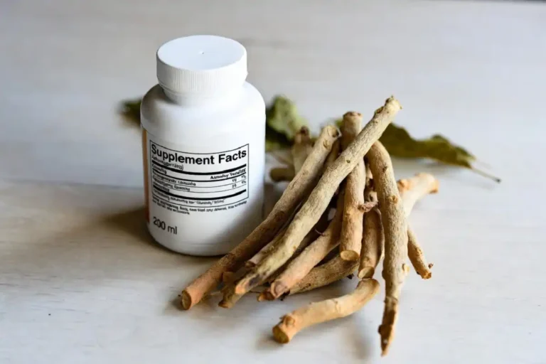 Ashwagandha Nature Made capsules beside fresh ashwagandha roots on a wood table