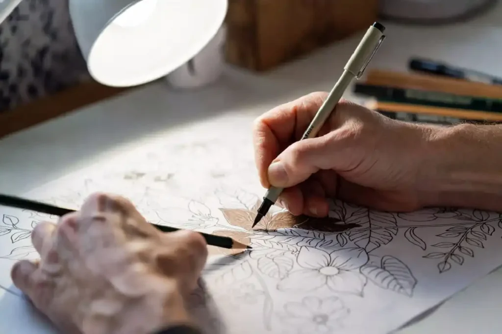 An adult coloring a detailed nature coloring page with fine-tip markers and colored pencils