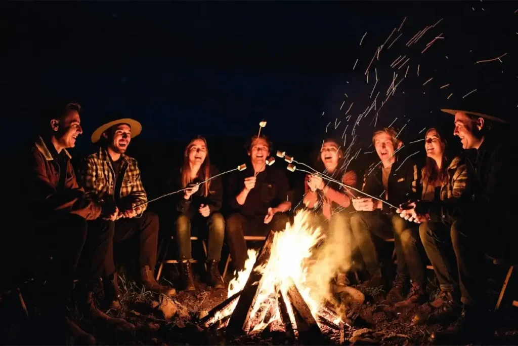 Friends celebrating together around a bonfire at night outdoors