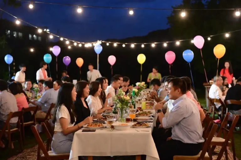 Outdoor celebration ideas setup with string lights balloons and a decorated dining table