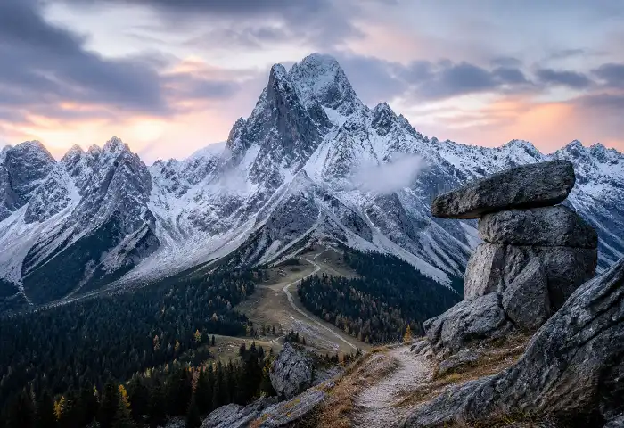 Snow-capped mountain range at dawn with pine forest below — mountain-inspired nature boy names