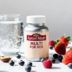Nature Made Multi for Her vitamin bottle on a wooden table with healthy breakfast