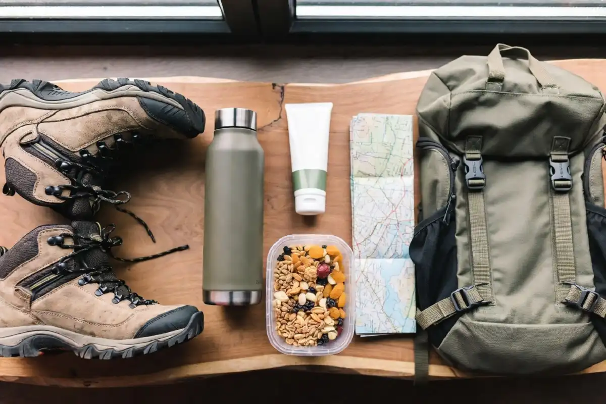 Essential nature walk gear including hiking boots, water bottle, backpack, and trail snacks