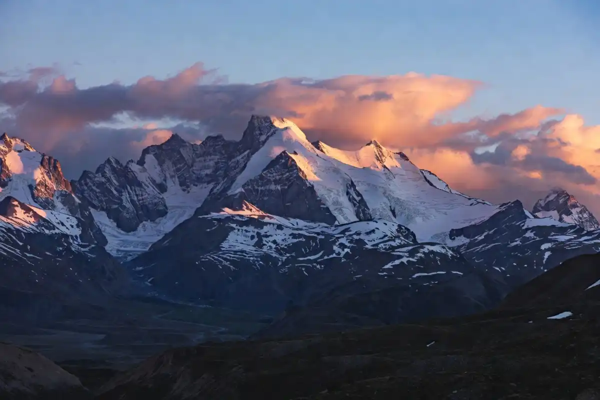 Snow-capped mountain peaks at sunrise illustrating quotes about nature and open landscapes