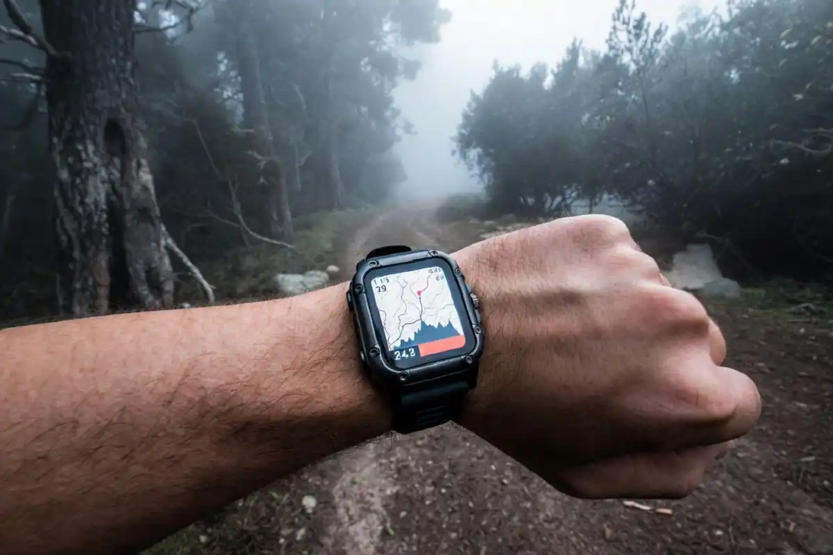 Hiker checking a GPS smartwatch on a forest trail