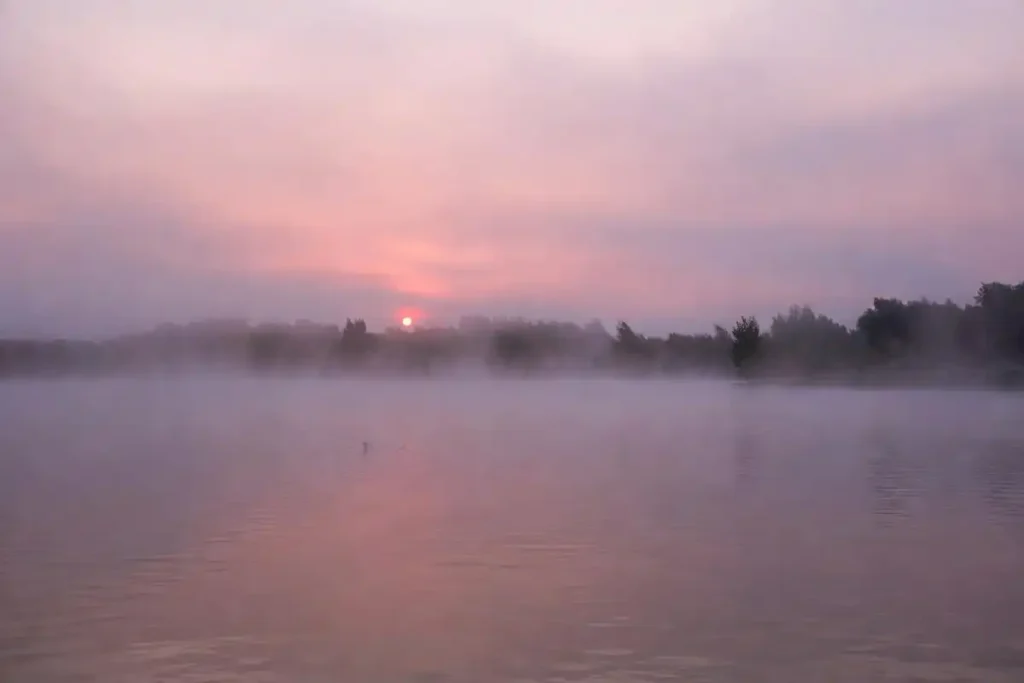 A misty dawn lake reflecting a pink sky, evoking water and sky-inspired nature girl names