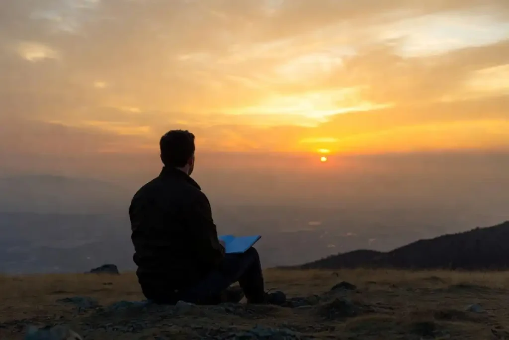 Person journaling at sunrise to find daily motivation and inspiration