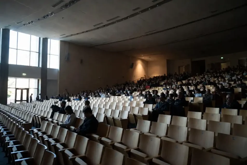 Engaged audience watching a TEDx talk inside a modern auditorium