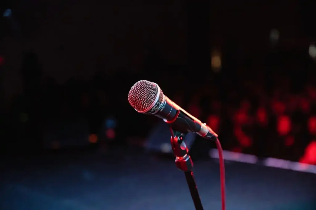 Close-up of a microphone on a red TEDx-style stage before a talk