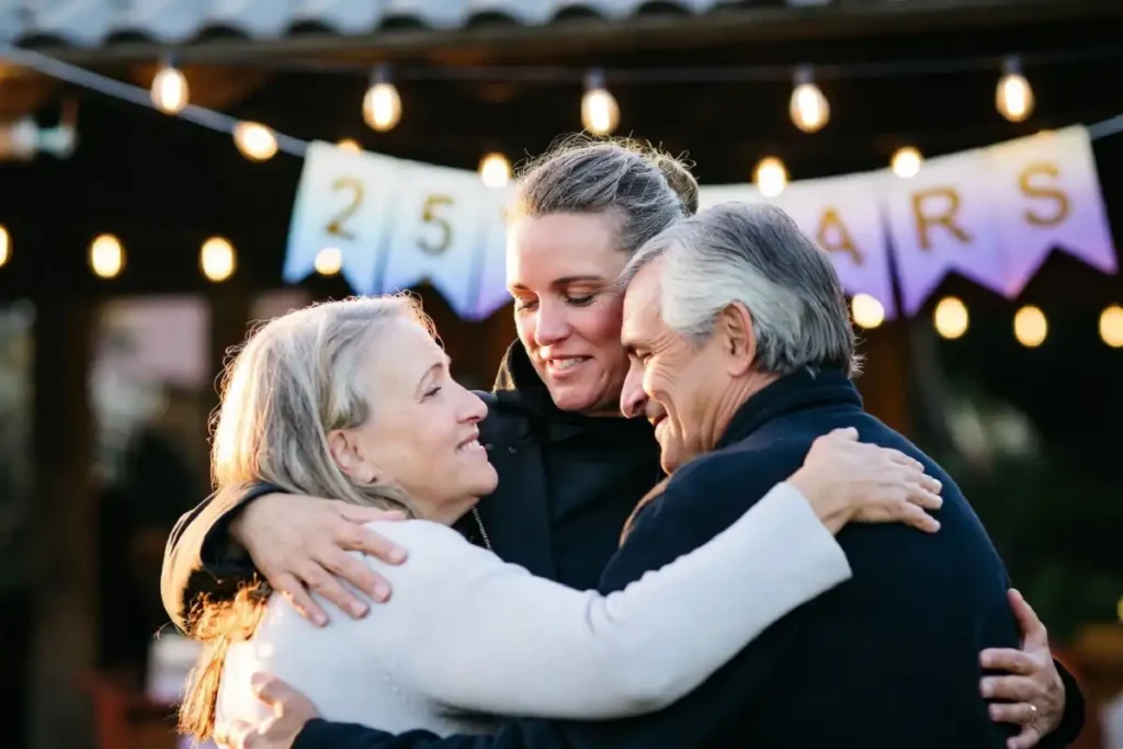 Adult child embracing parents at a milestone anniversary celebration